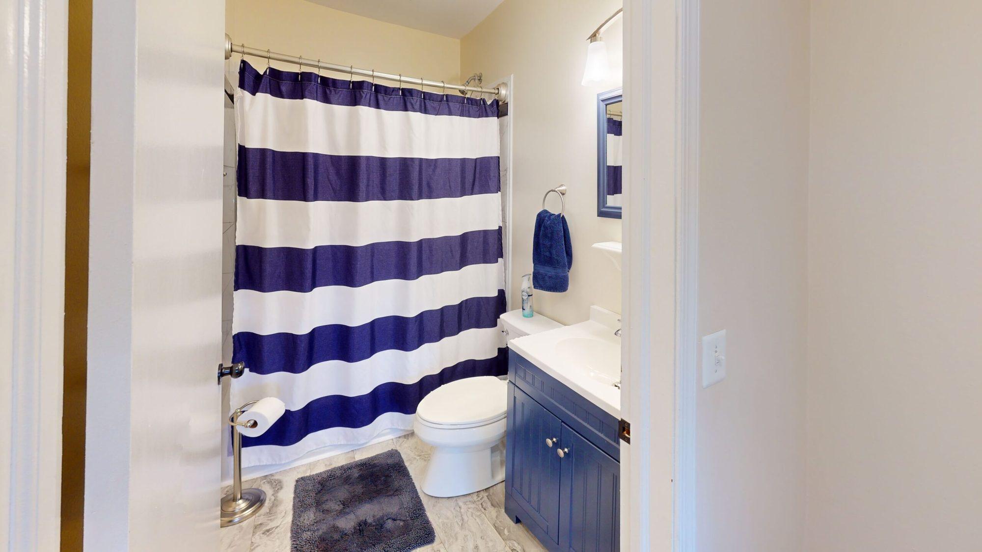 Bathroom with a navy vanity and striped shower curtain