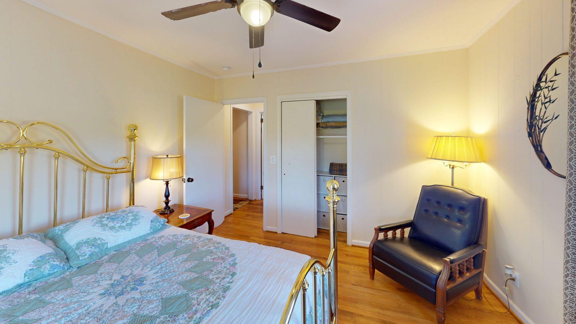 Bedroom with a brass bed and an armchair