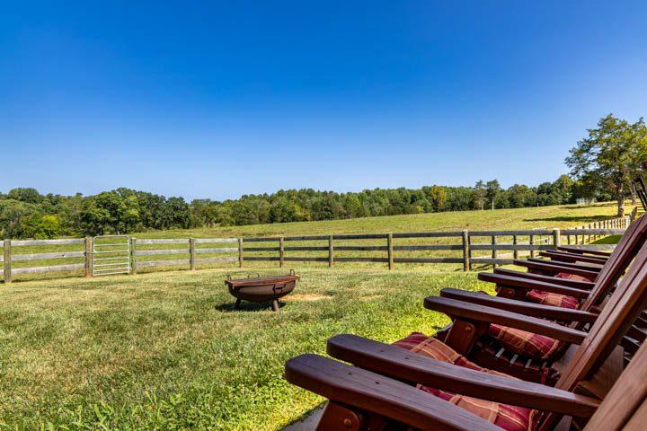 Adirondack chairs around a fire pit in the field