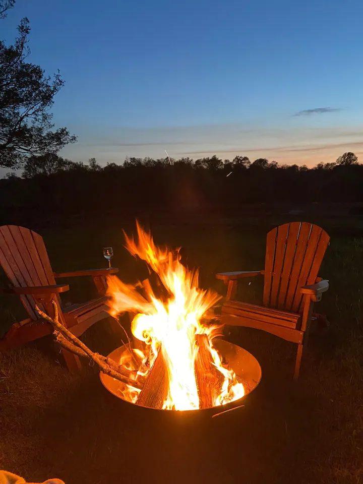 Fire pit and Adirondack chairs at dusk