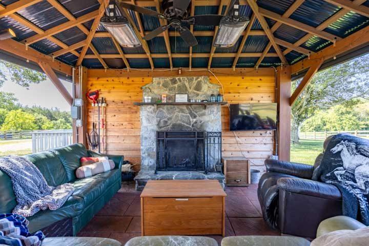 Pavilion sofas and a stone fireplace with a TV above