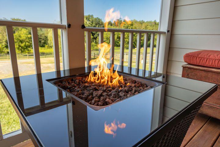 Gas fire table on the porch with pasture beyond