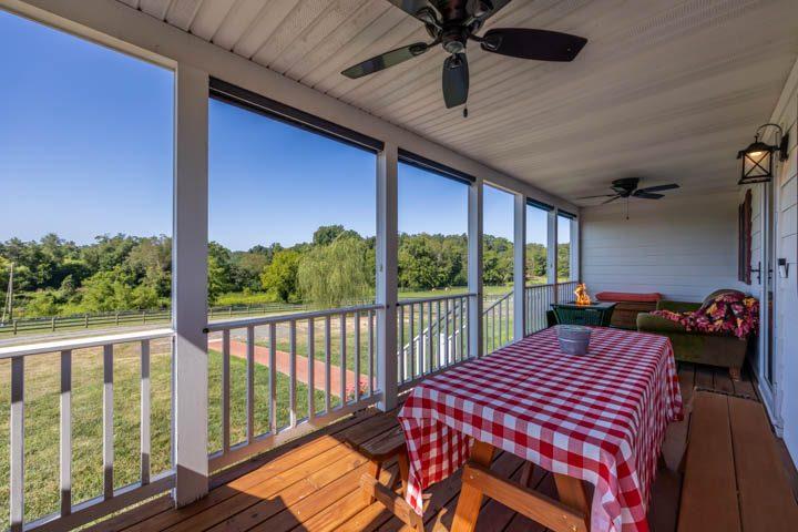 Screened porch with a dining table looking out over the pasture